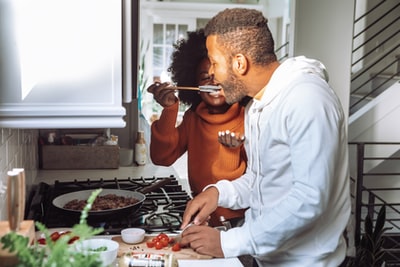 In a white and orange men long sleeve shirt with chopsticks
